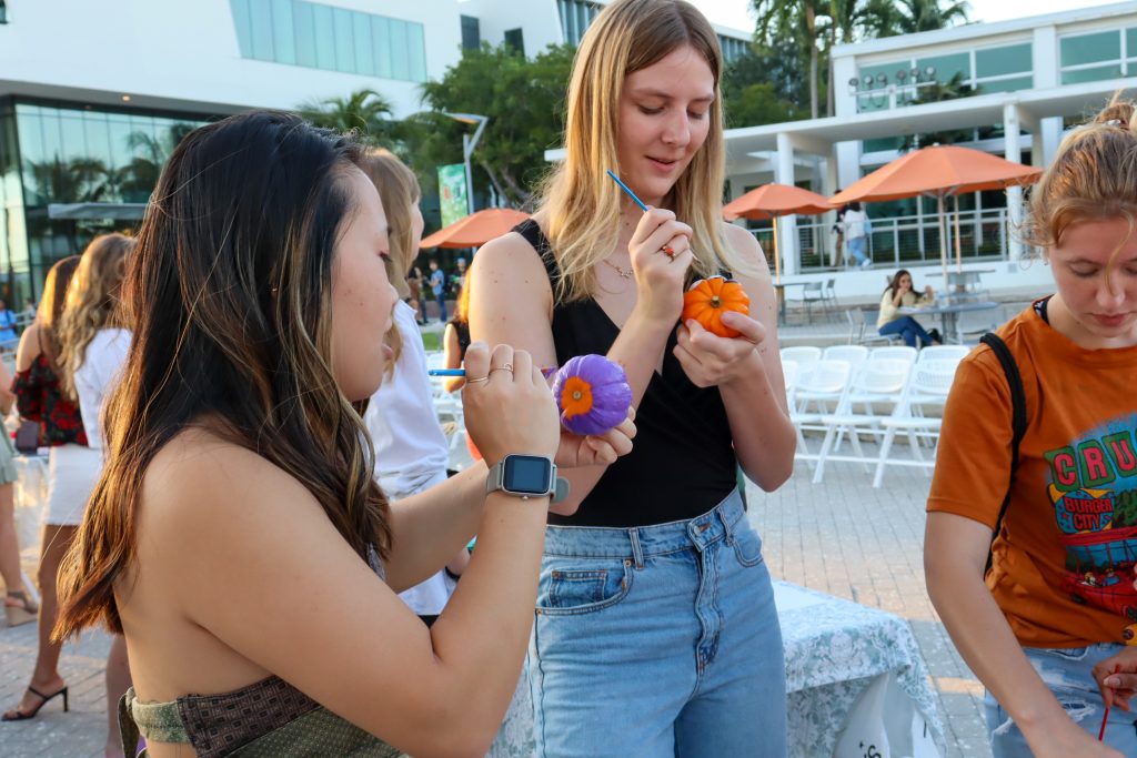 Allie Salvucci and Sophia Meibohm paint pumkins before the 3rd annual UThrift fashion show begins at the Lakeside Patio on Oct 26.