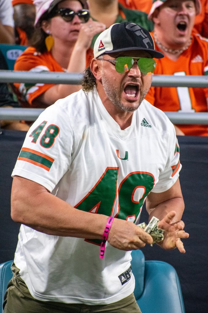 A fan pretneds to hand a referee cash during Miami's 27-24 loss to the University of North Carolina on Saturday, Oct. 8 at Hard Rock Stadium.