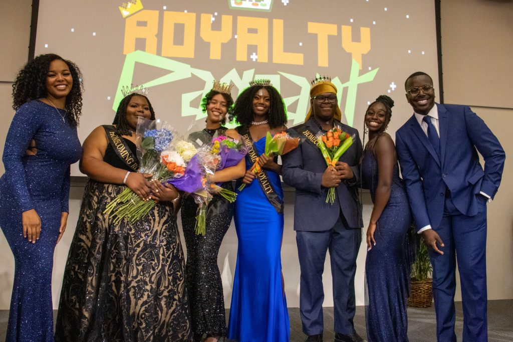 The four homecoming royalty members pose with the hosts of the Homecoming Royalty Pageant on Nov. 1 in the Shalala Ballroom.