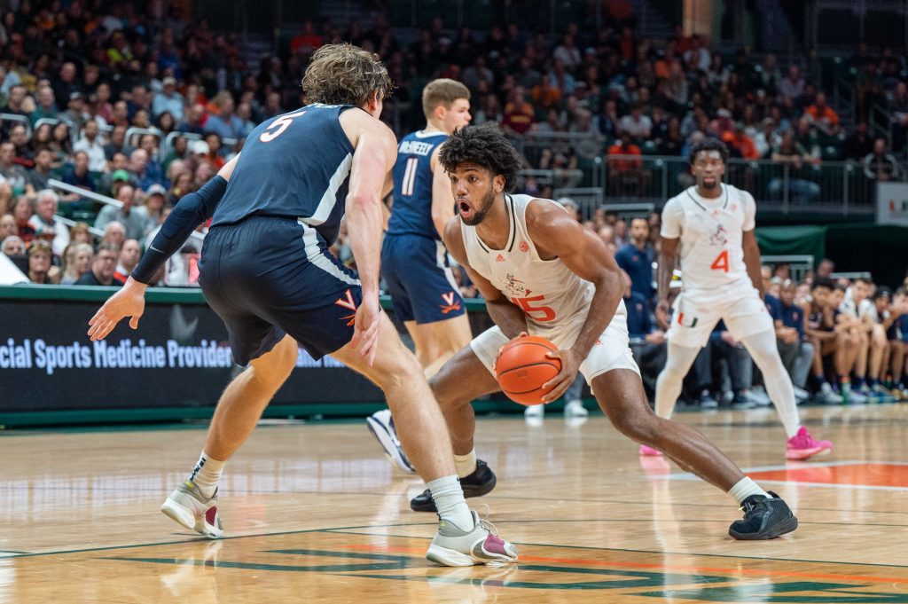 Third-years sophomore forward Norchad Omier dribbels around an opponent during MIami's win against the University of Virginia on Dec. 20 at the Watsco Center.