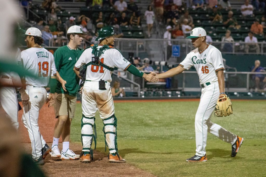 Catcher and pitcher duo high-five each other after ending the inning of the game against Stetson on Feb. 21 at Alex Rodriguez Park at Mark Light Field.