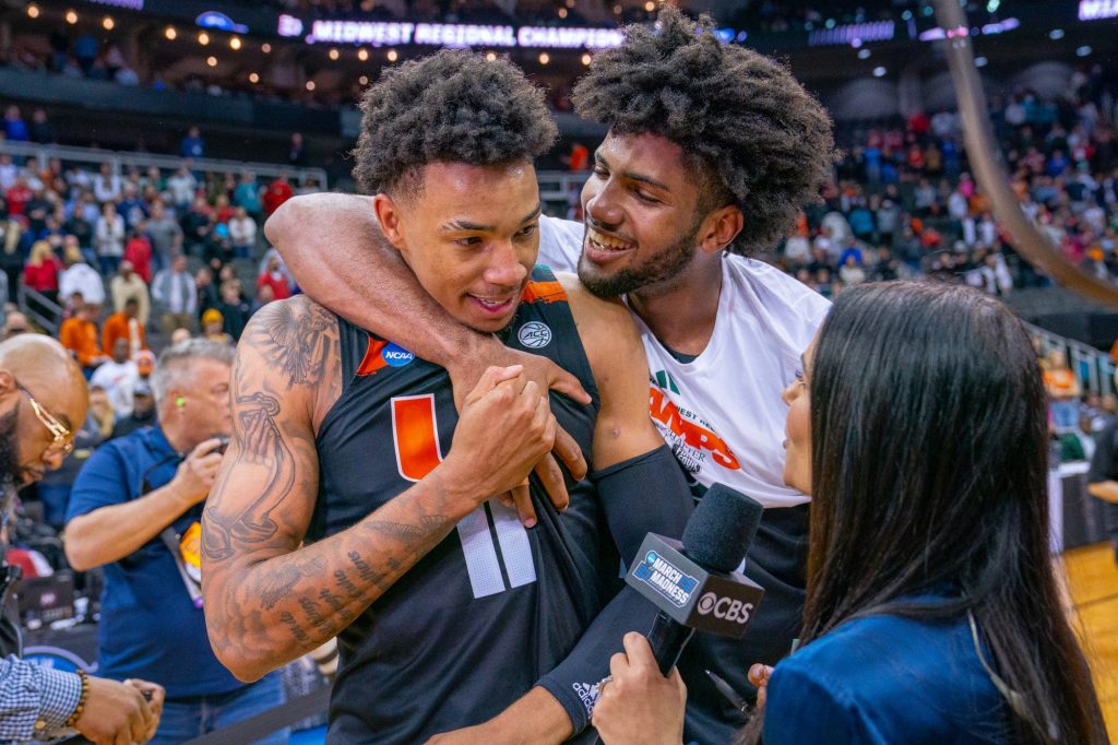 Third-year sophomore forward Norchad Omier hugs teammate fifth-year senior guard Jordan Miller as he gives an interview after Miami’s 88-81 Elite Eight win over the University of Texas in the T-Mobile Center in Kansas City, MO on March 26, 2023.