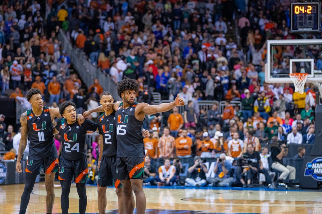 Third-year sophomore forward Norchad Omier gives The Miami bench a thumbs up while standing with teammate guards Jordan Miller, Nijel Pack and Isaiah Wong during the final seconds of Miami’s Elite Eight matchup against the University of Texas in the T-Mobile Center in Kansas City, MO on March 26, 2023.