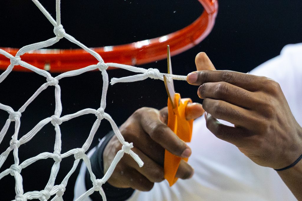 Freshman guard Christian Watson cuts a piece of the net following Miami's Elite Eight win over the University of Texas on Sunday, March 26 at the T-Mobile Center.